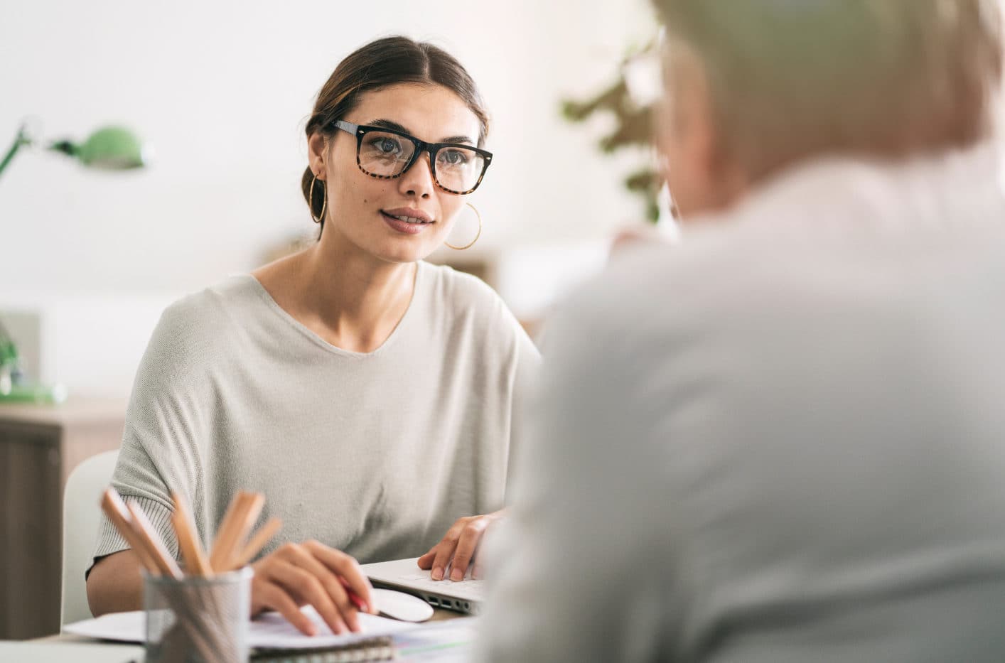 Une femme en pleine discussion professionnelle, concentrée et attentive à son interlocuteur.