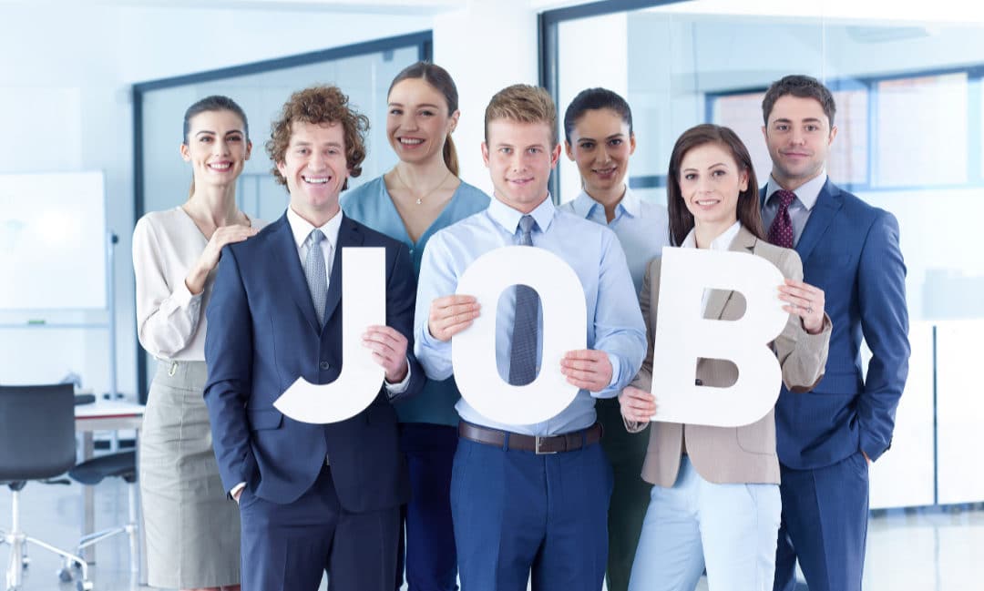 Groupe de professionnels en tenue de bureau tenant des lettres formant le mot 'JOB'.